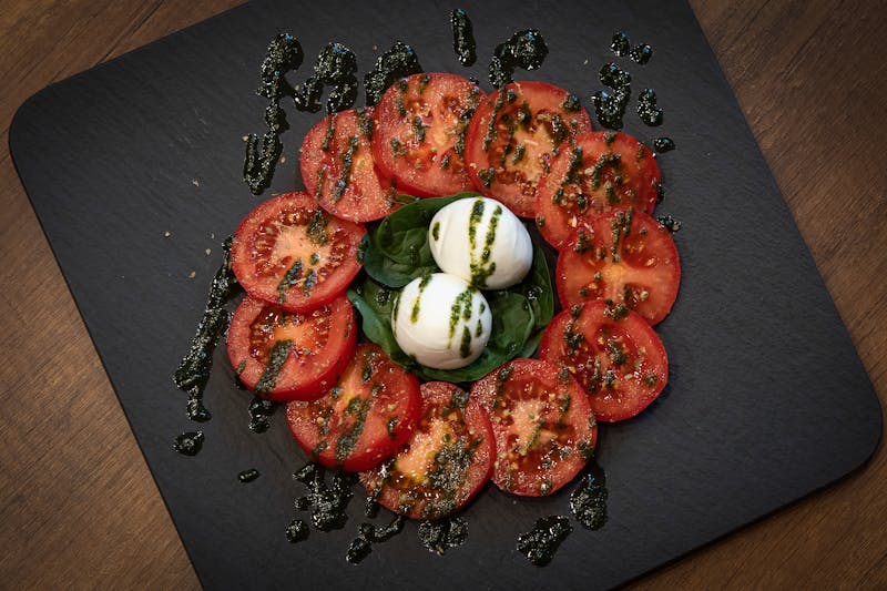 Burrata Caprese — creamy burrata with heirloom tomatoes at Pizzana